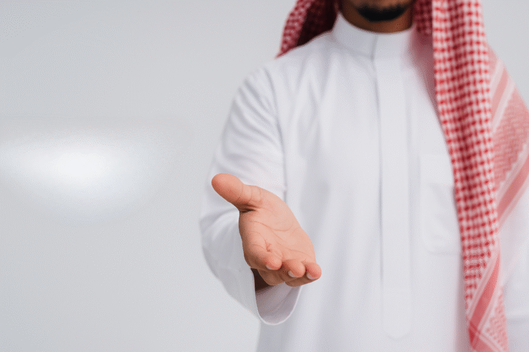 رجل أعمال سعودي يمد يده للمصافحة رمزًا للشراكة